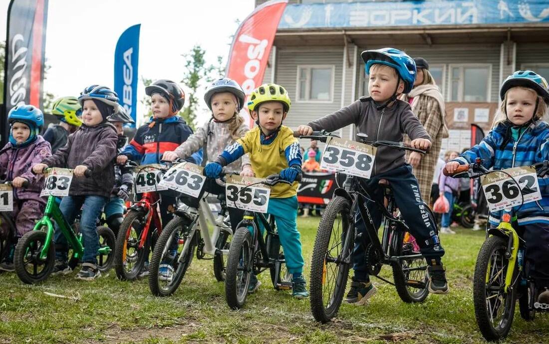 Дети бегут в спортивной одежде по полю.